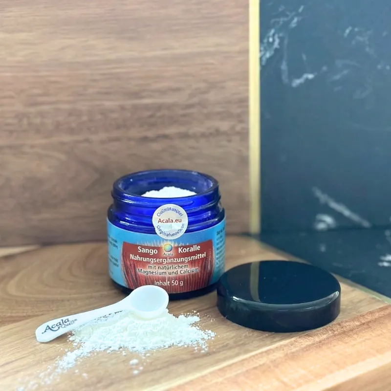 Sango Koralle  In einem blauen Glas Mit einem kleinen Löffel Auf einer Holzoberfläche