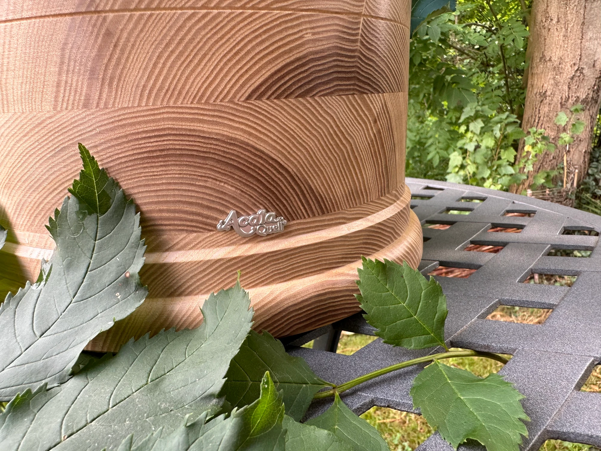 Ausschnitt eines Esche Echtholz Sockels von Acala im grünen Garten.