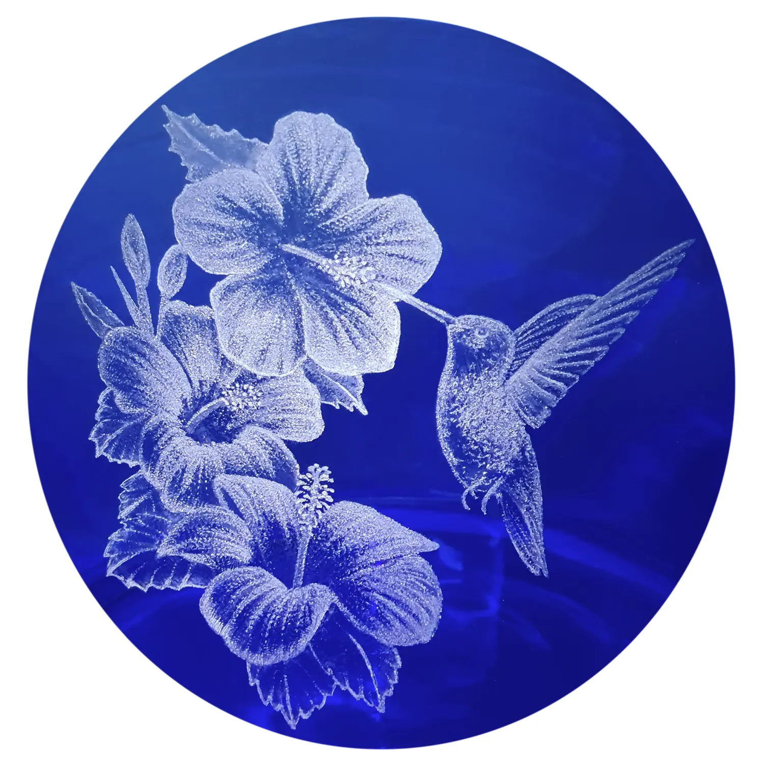 Vorratstank für einen Acala Wasserfilter Mini mit einer Handgravur. Die Gravur zeigt, auf blauem Glas, einen Kolibri der an einer offenen Blüte trinkt. Neben der Blüte sind noch zwei weitere ganz aufgeblühte Blüten. Nahaufnahme der Gravur