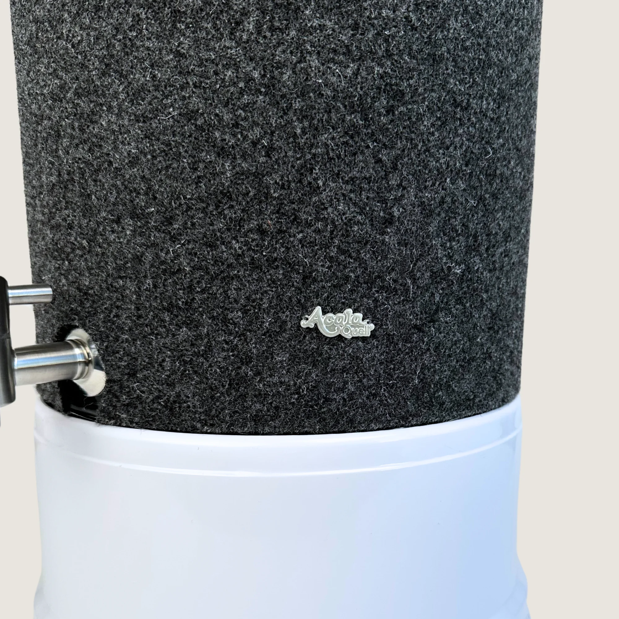 Ausschnitt eines Stand Wasserfilters von Acala mit Sockel in weiß, Edelstahl Wasserhahn Makino und Schurwolle Lichtschutz in anthrazit.