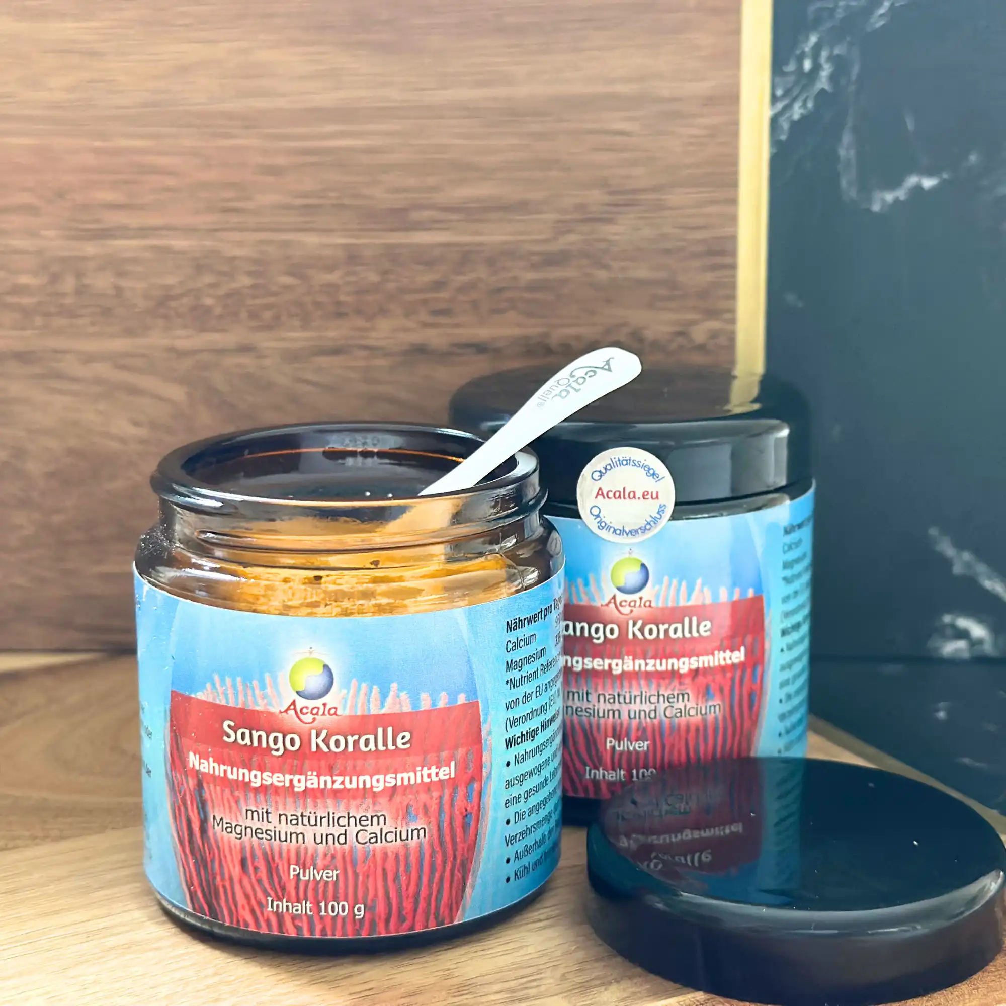 2 Gläser mit Sango Korallenpulver auf einer Holzplatte