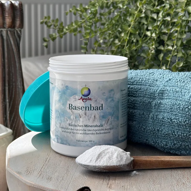 Basenbad Pulver in einer weißen Dose, davor liegt ein Holzlöffel mit dem Pulver