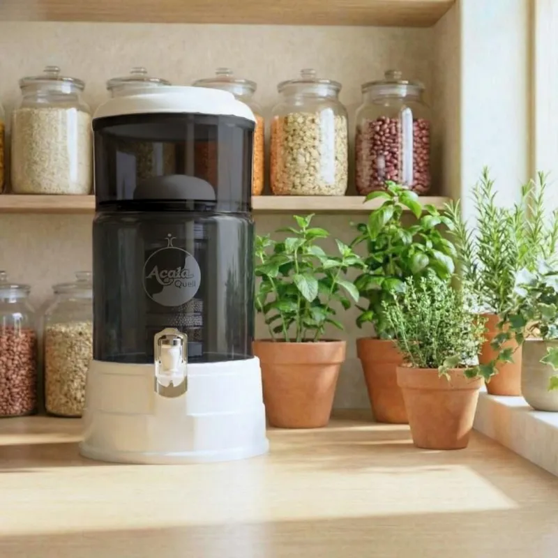 Miniwasserfilter Anthrazitfarbenes Glas weißer Deckel und Sockel steht vor einem Regal Auf dem Gläser stehen mit verschiedensten Körnern