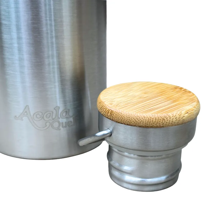 Nahaufnahme der Isolierflasche Thermi mit dem Deckel seitlich Man sieht dass der Deckel aus Edelstahl ist und die Kappe oben aus Bambusholz