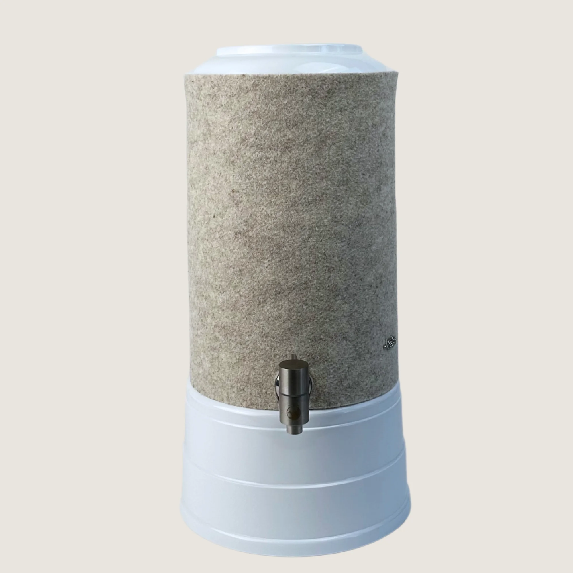 AcalaQuell Mini mit Sockel und Deckel in weiß, Edelstahl Wasserhahn und Schurwolle Lichtschutzüberzug in beige.