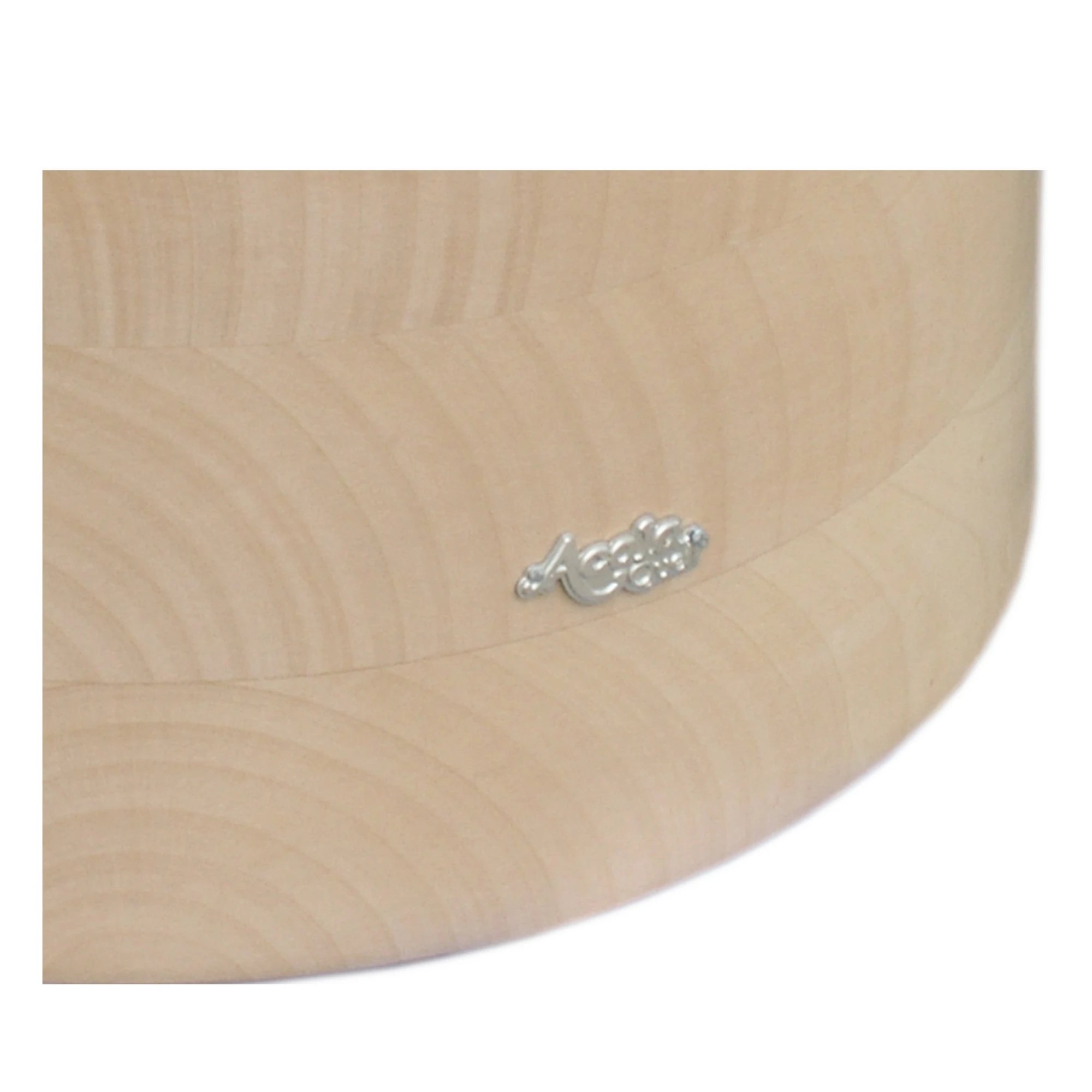 Zu sehen ist ein Großausschnitt eines Acala Echtholz Sockels aus Ahorn mit dem schlichten, silbernen Acala Logo darauf. 