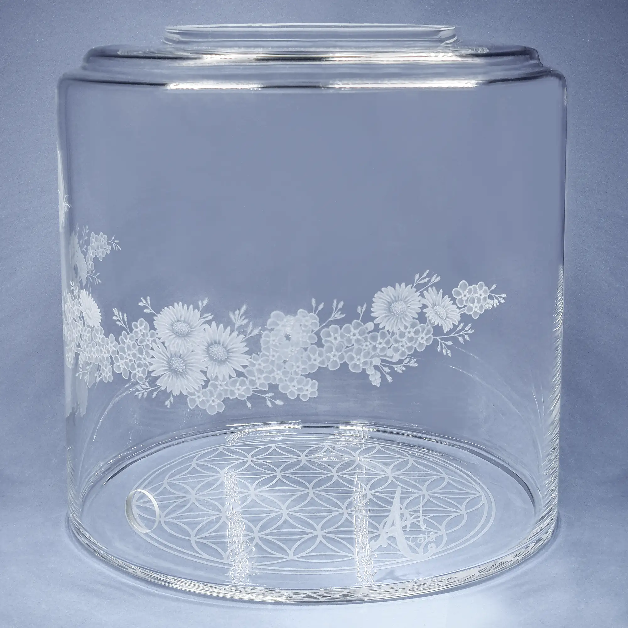 Vorratstank aus Glas für einen 8Liter Acala Wasserfilter in klarem Glas mit dem gravierten Kranz,umlaufende um das runde Glas.In dem Granz sind Vergissmeinnicht, Schmetterlinge und Gänseblümchen.Vorderansicht.