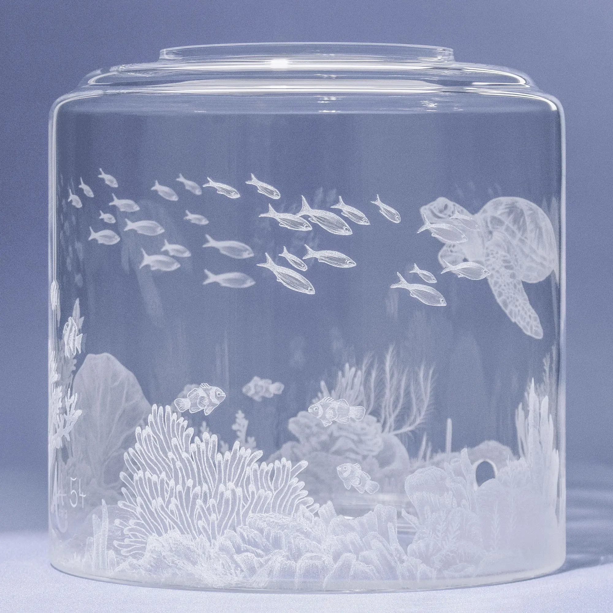 Auf dem Bild ist ein Wassertank für Acala Wasserfilter mit einer Handgravur die ein Riff mit Fischen,Korallen und einer schönen Schildkröte dargestellt wird,linke Seite