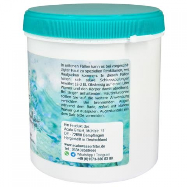 Zu sehen ist das Basenbad 700g. Es ist eine zylindrische, höhere Dose. Sie ist weiß mit türkisem Schraubdeckel. Es befindet sich ein Etikett rundherum auf der Dose, es ist grünlich. Man schaut auf die Rückseite wo die Inhaltsstoffe etc. beschrieben sind.