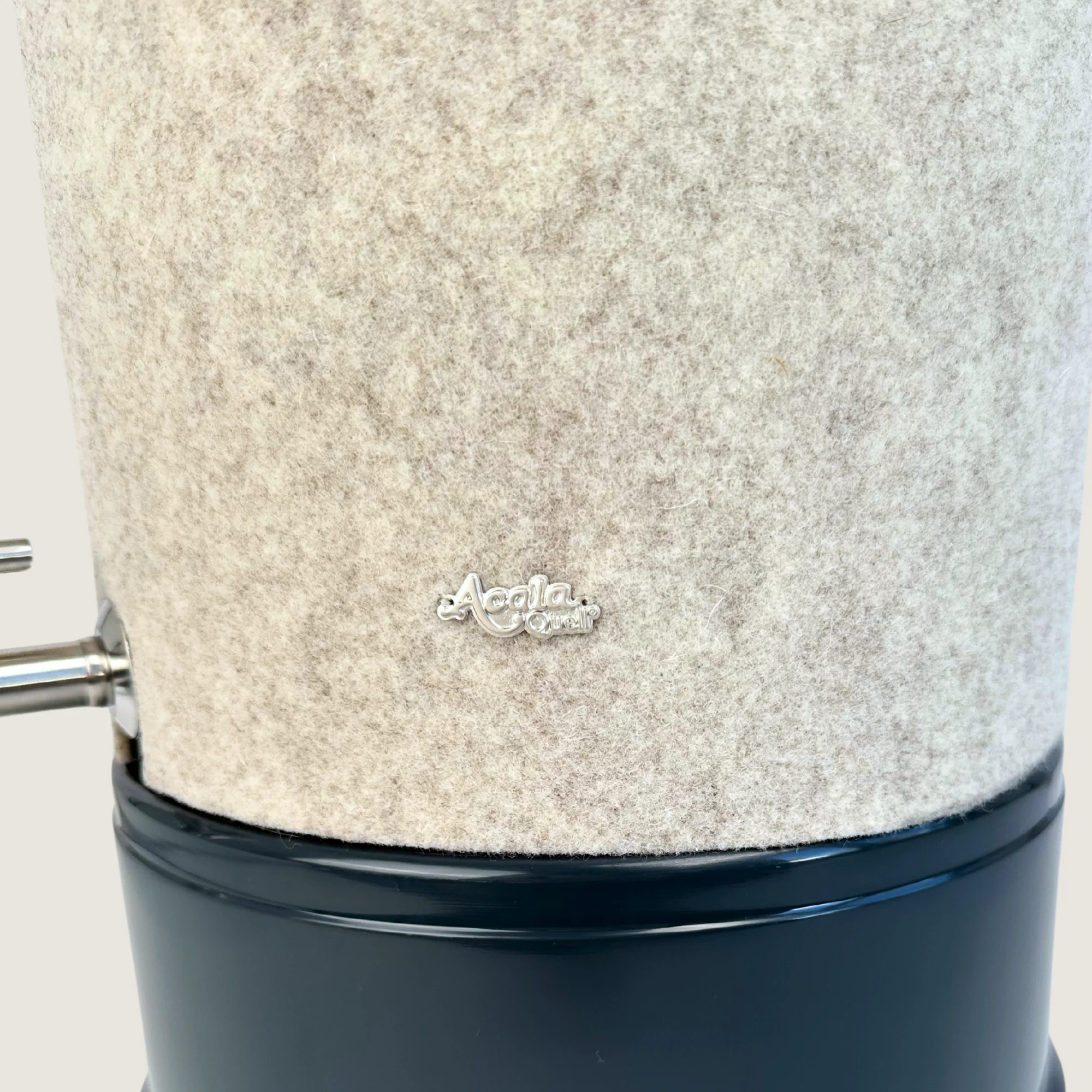Ausschnitt eines Stand Wasserfilters von Acala mit Sockel in anthrazit, Edelstahl Wasserhahn Makino und Schurwolle Lichtschutz in beige.