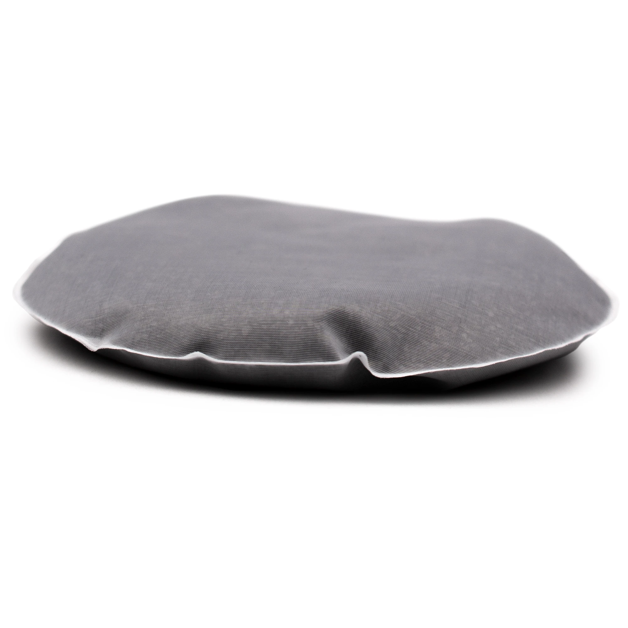 Ein schwarzes rundes Acala Quell Kalkfilter Pad flach liegend vor weißem Hintergrund.