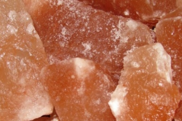 Zu sehen sind mehrere große Salzbrocken. Sie sind rötlich mit weißen Stellen und sehen aus wie große Kristalle.