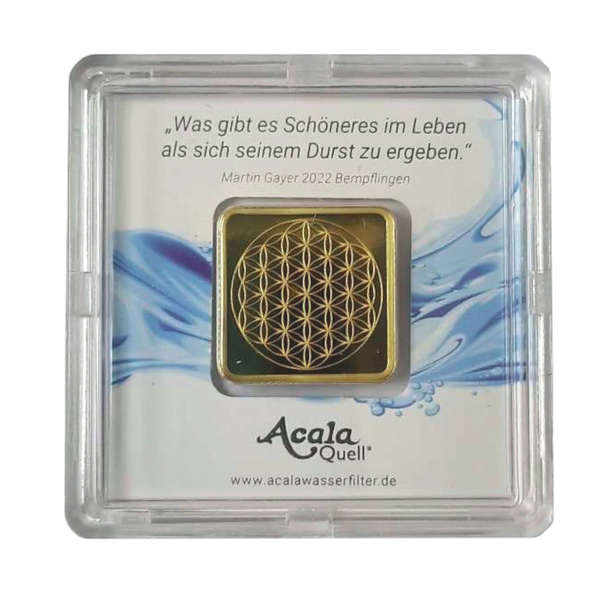 Zu sehen ist ein kleiner Goldbarren in einer Kunststoffkarte. Auf dem Goldbarren sieht man die Blume des Lebens. Das Bild zeigt die Rückseite des Goldbarrens von AcalaQuell.