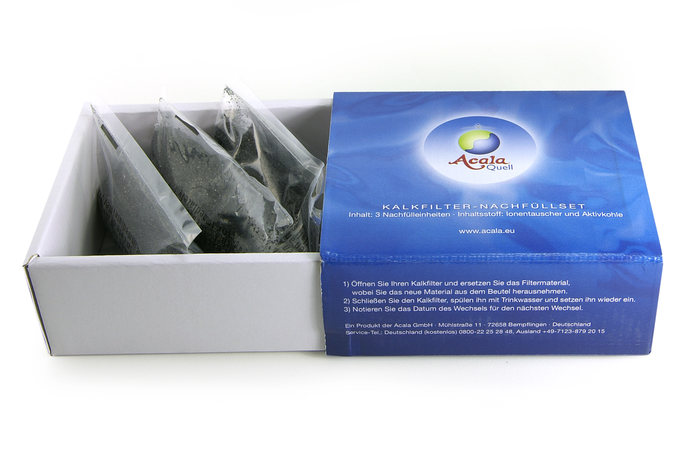 Kalk Nachfüll-Einsatz 3er Set für AcalaQuell® Stand Wasserfilter Ein offener blauer Karton mit 3 Beuteln mit schwarzem Kalkfiltergranulat für die Acala Stand Wasserfilter, weißter Hintergrund.