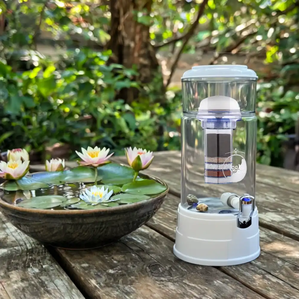 Runder Wasserfilter aus Glas, der fitler steht in einem Garten auf dem Tisch