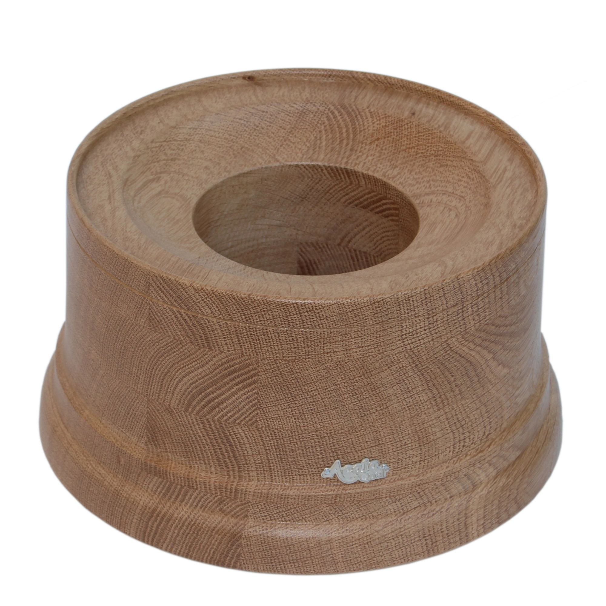 Zu sehen ist ein Sockel für den Acala Wasserfilter Mini aus wunderschön gemustertem Eiche Echtholz vor weißem Hintergrund. Auf dem Sockel befindet sich ein schlichtes, kleines, silbernes Acala Logo.