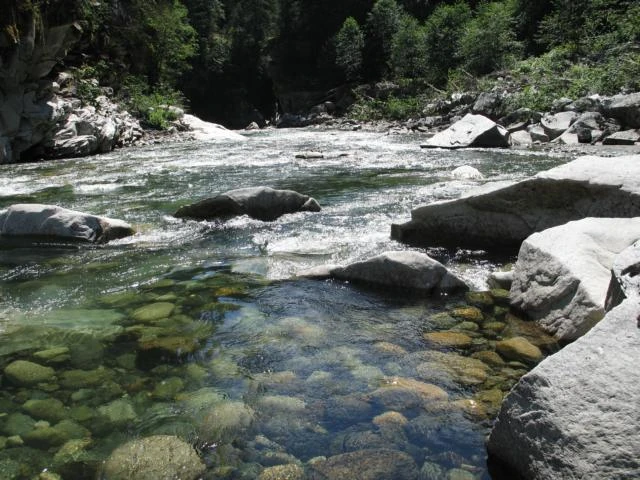 Sauberes Wasser schlängelt sich durch ein von Felsen gesäumtes Bachbett.
