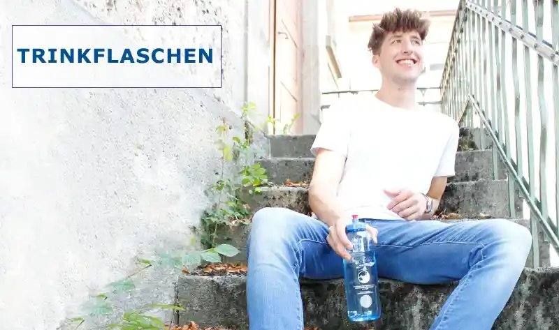 Junger Mann sitzt auf einer Treppe mit einer blauen Tritanflasche in der Hand