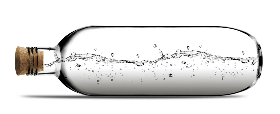 Flasche aus klarem Glas mit Waser gefüllt liegt auf der Seite