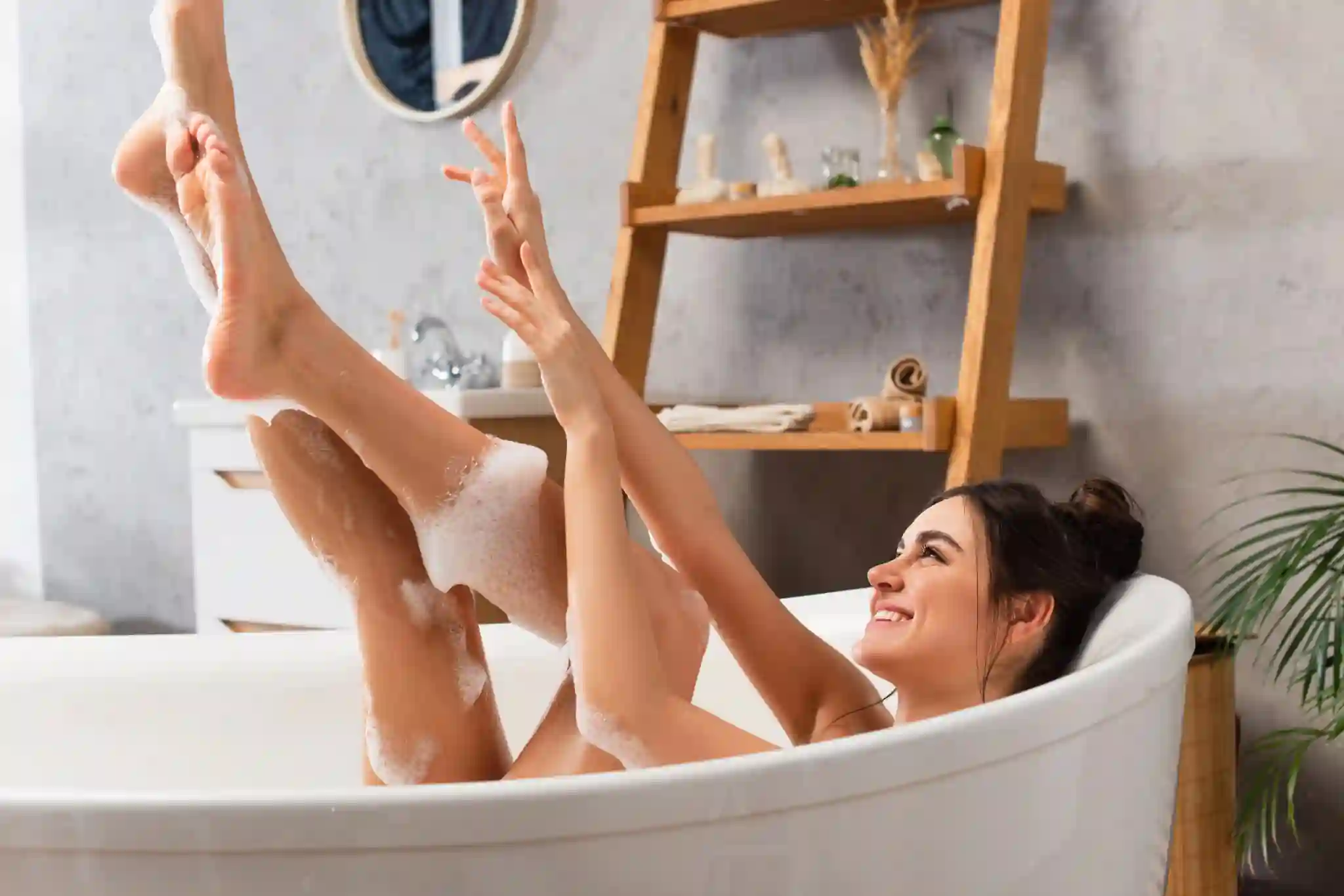 Frau in Badewanne, sie strahlt und freut sich über ihren Badespaß