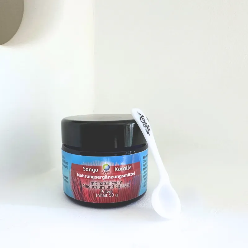 50 gramm sangokoralle in einem blauen Glas Vor einem weißen Hintergrund mit einem kleinen Kunststofflöffel